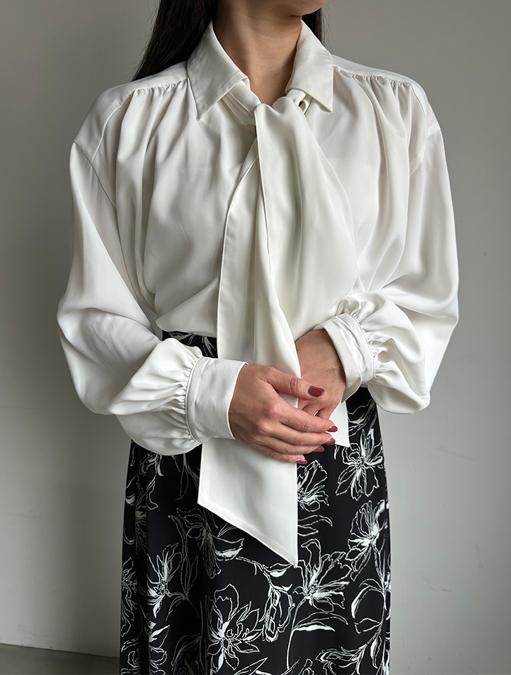 取外し可能タイ付きスキッパーブラウスを花柄スカートに合わせた、華やかな印象のレディース・オフィスカジュアル術